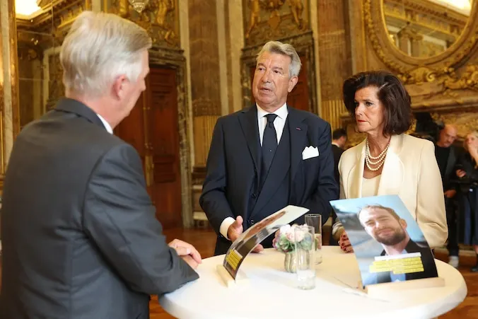 Le roi Philippe face à Patrick et Donatienne, autour d'une table haute au Palais royal