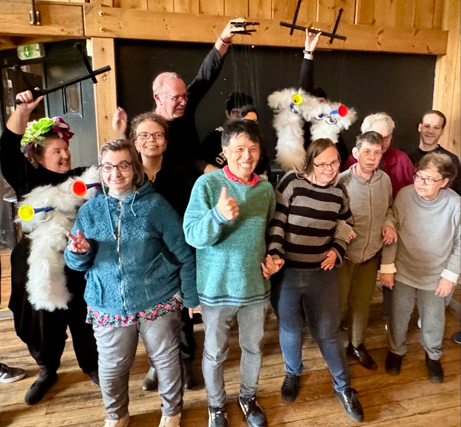 Invités et bénévoles participent à un spectacle de marionnettes.