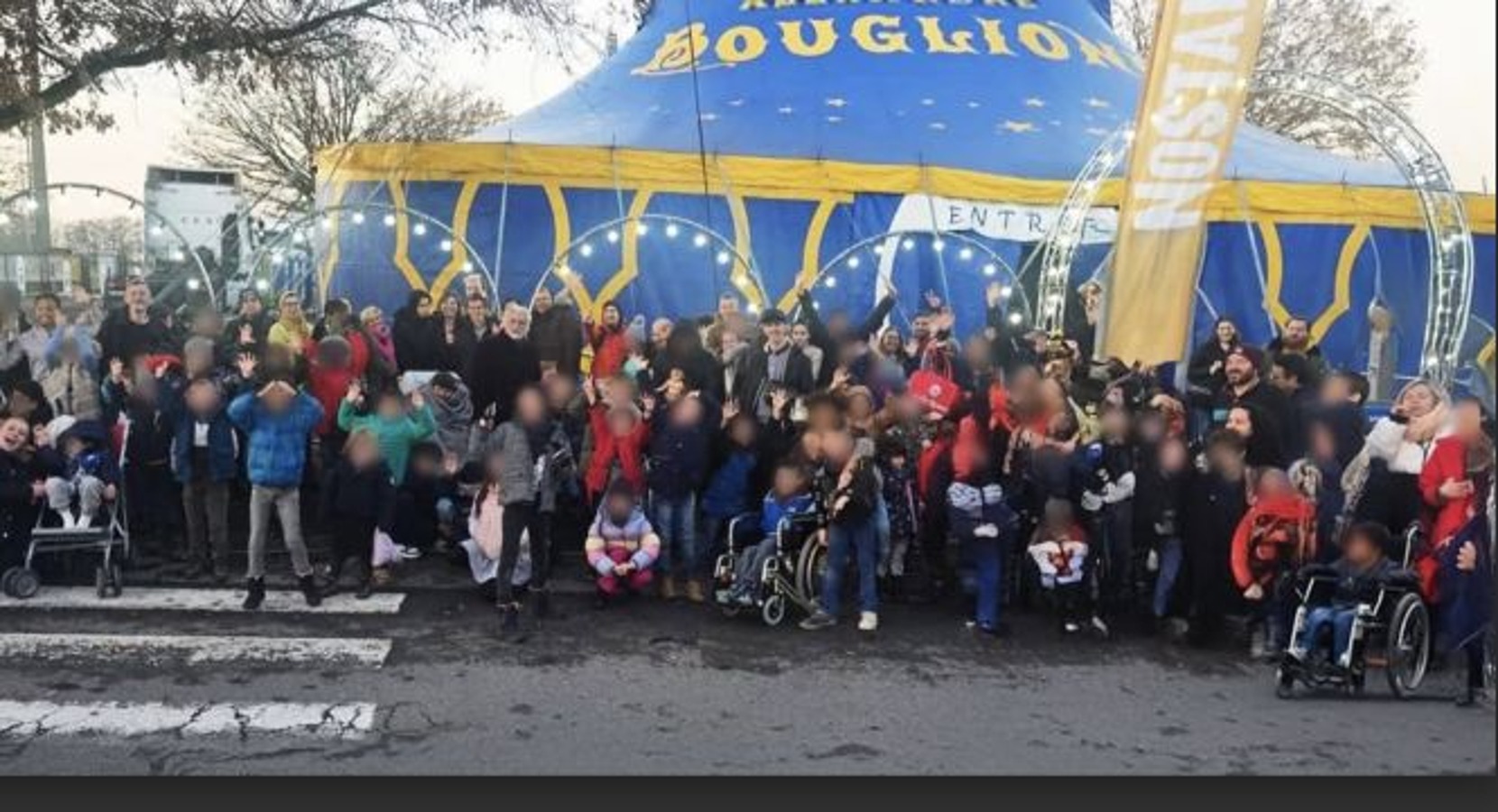 Un grand groupe réuni devant le chapiteau du cirque Bouglione.