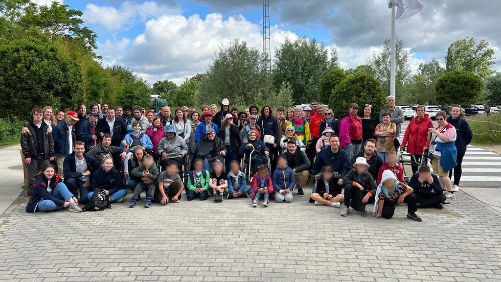 Le groupe pose ensemble à l’extérieur, près d’un parc.