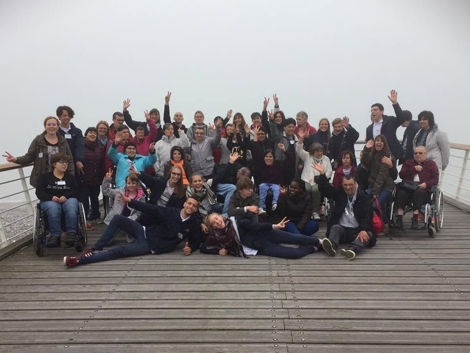 Le groupe salue l’appareil depuis un ponton, dans la brume.