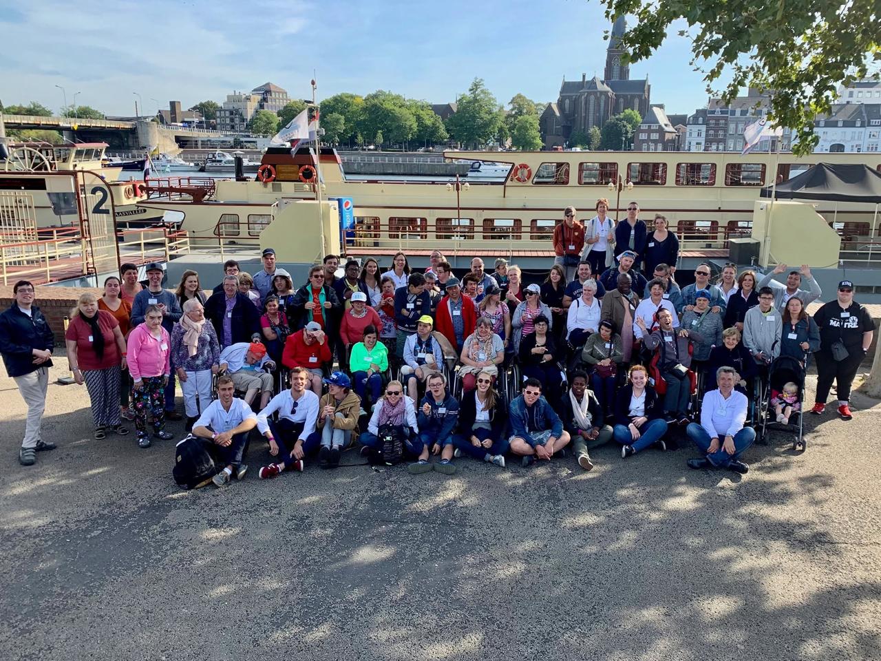 Le groupe pose sur un quai, devant un bateau.