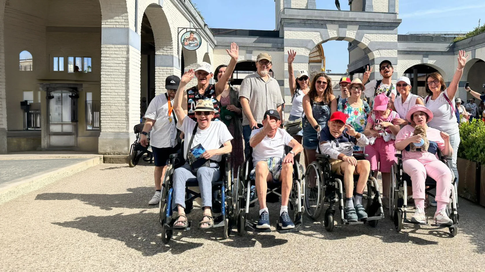 Invités et bénévoles réunis pendant une sortie, avec plusieurs personnes en fauteuil roulant au premier rang